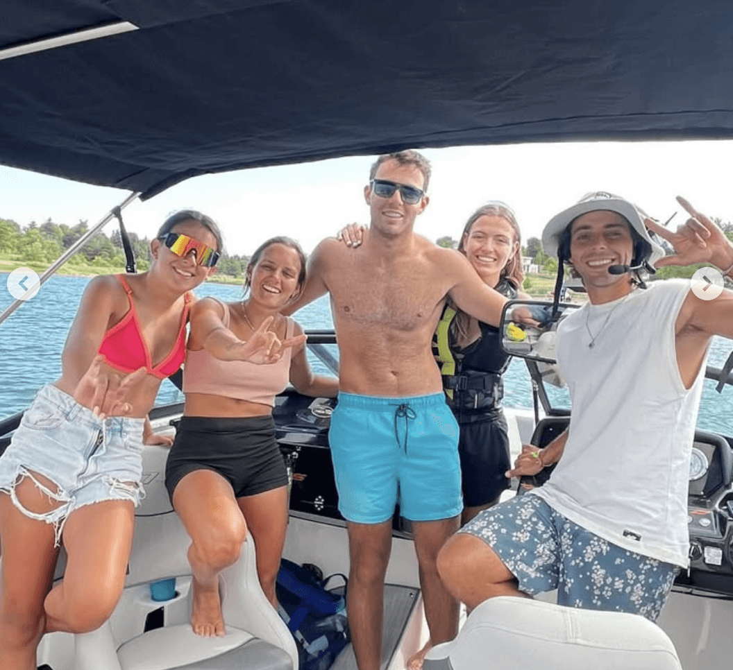 Group of riders hanging out on the wakeboard boat between sets